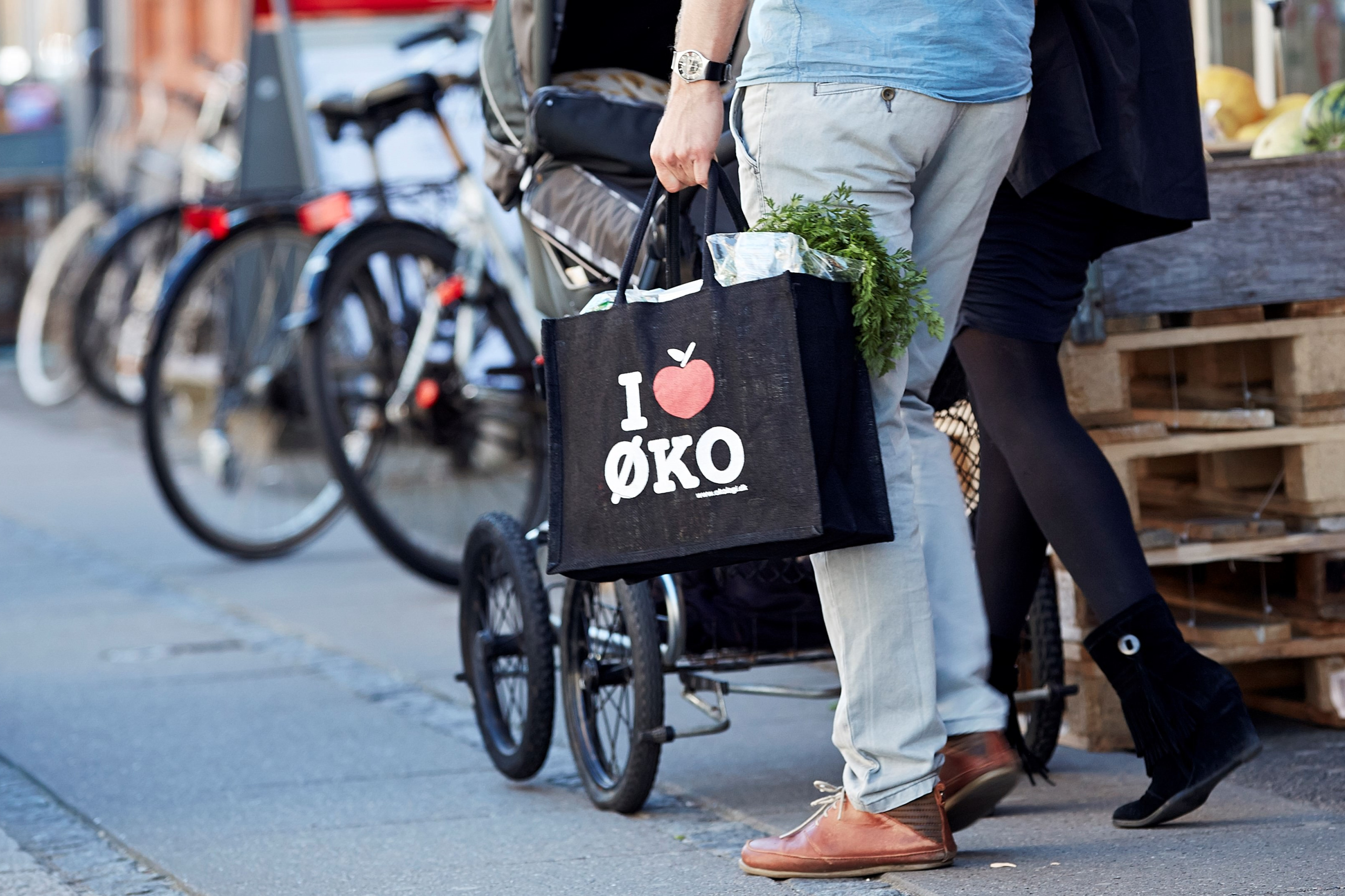 Et par går med et I Love Øko-net på vej ud af et supermarked